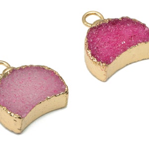 Può includere: Due ciondoli a forma di mezzaluna placcati in oro con accenti di cristallo rosa e rosa chiaro. I ciondoli hanno un anello nella parte superiore per essere attaccati ai gioielli.