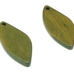 May include: Two green wooden leaf-shaped pendants with a hole at the top for hanging.