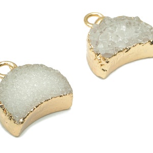 Può includere: Due ciondoli a forma di mezzaluna placcati in oro con una texture bianca simile al cristallo.