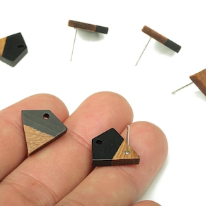 May include: Geometric stud earrings with a two-tone design. Each earring features a combination of black and natural wood tones in a triangular or rectangular shape. The earrings have silver-coloured posts.