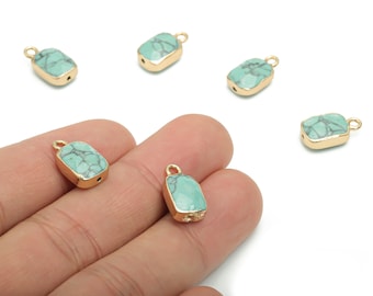 May include: Rectangular turquoise gemstone pendants with gold-colored bezels. The pendants have a small loop at the top for stringing. The turquoise has a mottled pattern of light and dark blue-green. Several pendants are visible.