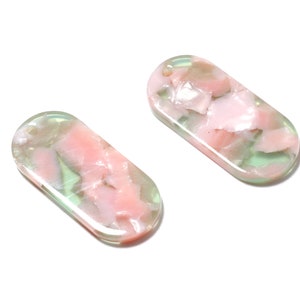 May include: Two oval-shaped, translucent green and pink resin beads. The beads have a marbled pattern with swirls of pink and green.