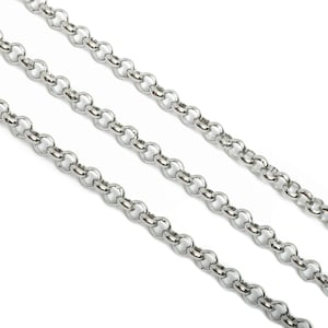 May include: Three silver chains with a delicate, round link design. The chains are laid out in parallel lines on a white background.