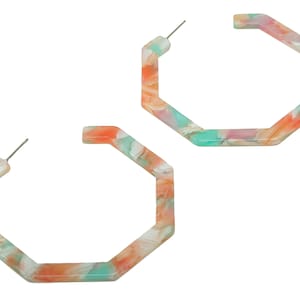 Puede incluir: Un par de pendientes grandes de aro octogonales hechos de plástico marmoleado de colores. Los pendientes son una mezcla de rosa, naranja y verde.