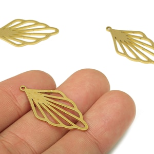 May include: Three gold-coloured leaf-shaped charms. Each charm has a small hole at the top for stringing. The charms have a detailed, openwork design with multiple lines radiating from the base, resembling a stylized leaf.