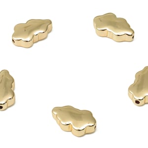 May include: Five gold-coloured metal cloud-shaped beads with a hole in the centre for stringing.