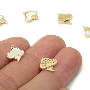 Peut inclure: Charm en forme de nuage doré avec un éclair. Certains présentent un nuage blanc et un éclair doré, d'autres sont entièrement dorés avec un motif de nuage perforé. Idéal pour la création de bijoux.