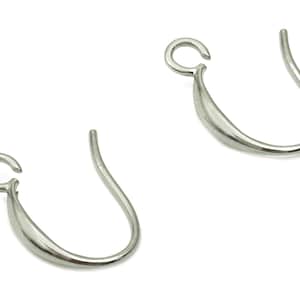 Könnte beinhalten: Zwei silberne Ohrhaken mit einem geschwungenen Design. Die Haken sind aus Metall und haben eine glatte Oberfläche.