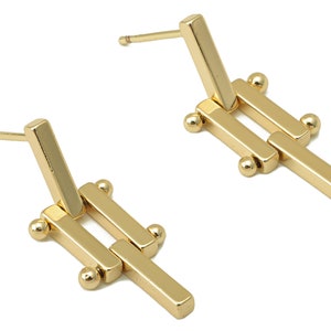 May include: A pair of gold-toned geometric earrings with a linked bar design and small round accents.