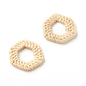 Puede incluir: Dos anillos hexagonales tejidos de color marrón claro. Los anillos están hechos de materiales naturales y tienen un aspecto rústico y hecho a mano.