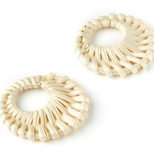 Puede incluir: Dos piezas redondas decorativas tejidas de color crema con un agujero en el centro.