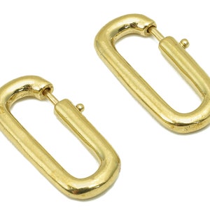 May include: Two gold-toned metal oval-shaped clasps with a smooth finish.