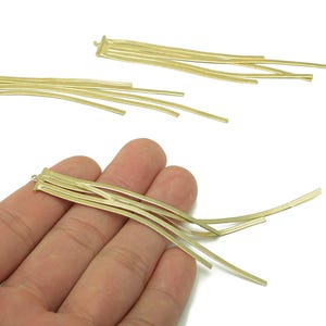 Peut inclure: Composants de franges en métal doré. Chaque composant comporte plusieurs brins fins et incurvés attachés à une petite base rectangulaire. Les composants sont présentés sur fond blanc.