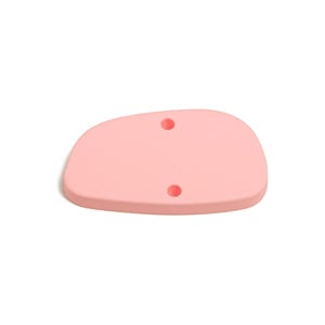 Puede incluir: Una herramienta de costilla de cerámica de color rosa claro, de forma orgánica, con dos agujeros circulares. Esta herramienta se utiliza para dar forma y alisar la arcilla en cerámica y cerámica. La herramienta está hecha de un material flexible.