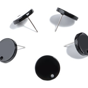 Op de afbeelding: Vijf zwarte, ronde oorstekers met zilveren pinnen worden getoond tegen een witte achtergrond. Elke oorbel heeft een glanzende afwerking en een klein gaatje bij de pin. De oorbellen hebben een eenvoudig, minimalistisch ontwerp.
