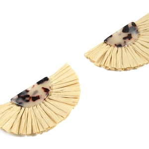 May include: A pair of cream-coloured tassel earrings with a tortoiseshell-patterned half-circle accent.