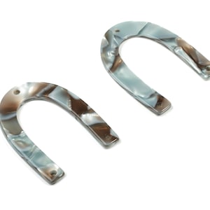 May include: Two white and brown marbled plastic horseshoe-shaped hair clips.