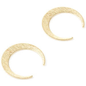 May include: A pair of gold crescent moon earrings. The earrings are made of a brushed metal and have a simple, minimalist design.