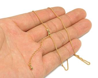 May include: A delicate gold-colored necklace with a chain-link design. The necklace features an adjustable chain and a lobster clasp closure. The jewelry is displayed against a neutral background.