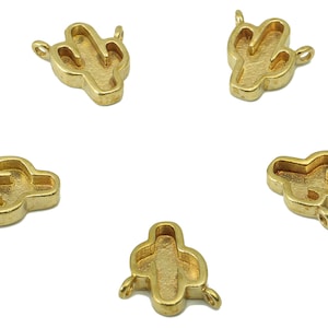 May include: Five gold-coloured metal cactus charms with open centres. Each charm has a loop for attaching to a necklace, bracelet, or other jewellery.
