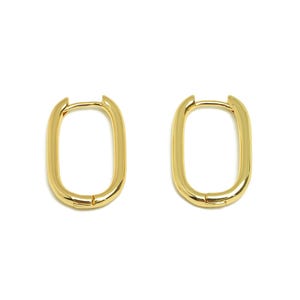 May include: A pair of gold-colored, rectangular hoop earrings. The earrings have a smooth, polished finish and a simple, modern design. The earrings are shown against a white background.
