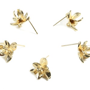 以下が含まれることがあります： 金色の花の形をしたスタッドピアスが4つ。それぞれのピアスは、繊細な3次元の5枚の花びらを持つ花のデザインが施されています。