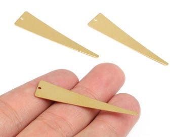 May include: Gold-colored, elongated triangle-shaped metal jewelry findings. Each finding has a small hole at the top for attaching to other components. One is held in a hand, with two others displayed separately.