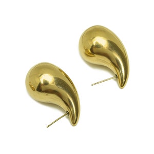 May include: A pair of gold teardrop-shaped earrings with a simple post design.
