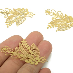 May include: Three gold-colored metal leaf and floral embellishments. The detailed cut-outs feature various leaf shapes and small floral accents. These decorative elements are ideal for jewelry making or craft projects.