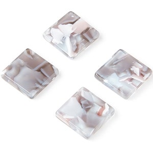 May include: Four square-shaped, translucent, white and gray resin tiles with a marbled pattern.