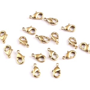 Peut inclure: Un groupe de 16 fermoirs à ressort en métal doré, souvent utilisés pour la fabrication de bijoux.