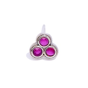 May include: A silver nose ring with three pink gemstones in a triangular shape.
