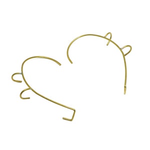 Può includere: Due fasce per capelli in metallo dorato a forma di cuore. Ogni fascia ha tre piccoli anelli alle estremità.