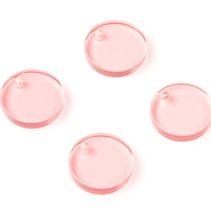 May include: Four pink, round, acrylic discs with a small hole in the center of each disc.