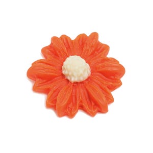 May include: A bright orange flower with a white center. The flower is made of plastic and has a glossy finish.