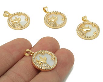 May include: Gold-colored pendant necklaces with a round design. Each pendant features a white background with a gold-colored bull, surrounded by a ring of small, clear crystals. The pendants have a small loop at the top for a chain.