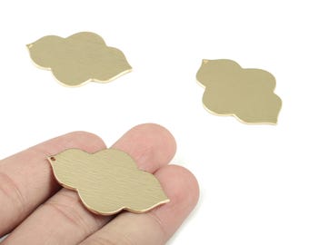 Può includere: Tre ciondoli in metallo color oro a forma di nuvola. Un ciondolo è tenuto in mano. I ciondoli hanno una superficie strutturata e un piccolo foro nella parte superiore per l'infilatura.