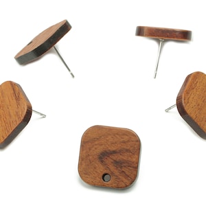 May include: Five wooden earrings with a square shape and a small hole in the center. The earrings are made of dark brown wood with a natural grain pattern. The earrings are attached to silver posts.
