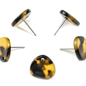 Puede incluir: Cinco pares de pendientes de botón de carey con postes de plata. Los pendientes son de varias formas, incluyendo redonda, ovalada y triangular.