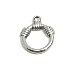 Può includere: Ciondolo in metallo argentato con un design circolare. Il ciondolo presenta una forma ad anello con dettagli avvolti sui lati e sulla parte superiore. Il ciondolo ha un piccolo anello nella parte superiore per il fissaggio ai gioielli. Il ciondolo è su sfondo bianco.