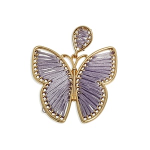 Può includere: Un ciondolo a farfalla color oro con dettagli in filo lavanda. Le ali della farfalla sono riempite con fili paralleli e i bordi sono delineati con piccole perle dorate. Il ciondolo ha un pezzo superiore abbinato.