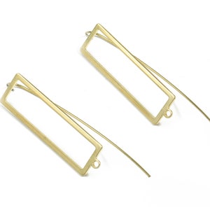May include: A pair of gold-toned rectangular earring blanks with a wire loop at the bottom. The blanks are open on the top and bottom, allowing for the insertion of a variety of materials.