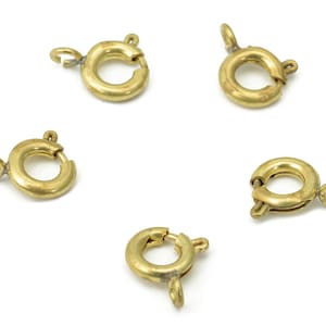 Puede incluir: Cinco cierres de langosta de metal dorado, cada uno con un anillo redondo y un cierre de resorte.