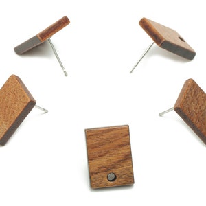May include: Five pairs of wooden earrings with a rectangular shape and a small hole in the centre. The earrings are made of a dark brown wood with a natural grain pattern.