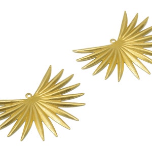 May include: Two gold-toned metal palm leaf shaped charms with a hole at the top for attaching to jewelry or other crafts.