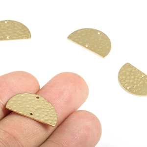 May include: Four gold-colored, half-circle shaped metal jewelry findings. Each piece has a hammered texture and two small holes for attaching to other components. The findings are shown against a white background.