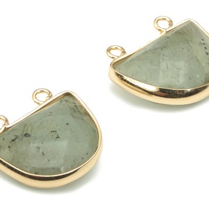 Può includere: Due ciondoli a forma di semicerchio in metallo dorato con inserti di pietre preziose verdi. Ogni ciondolo ha due anelli a salto per il fissaggio a gioielli.