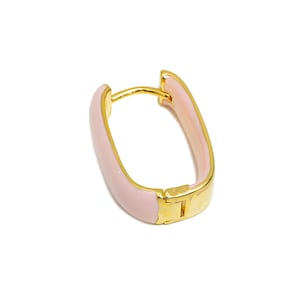 May include: A pair of gold hoop earrings with a pink enamel finish. The earrings are oval shaped and have a hinged closure.