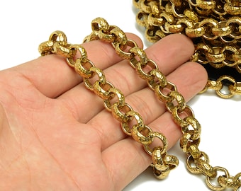 Könnte beinhalten: Nahaufnahme einer goldenen Kette mit einer strukturierten, gehämmerten Oberfläche. Die Kette ist aus Metall und hat einen dicken, kühnen Look.