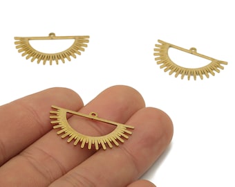 May include: Gold-colored metal sunburst charms. The charms are in a half-circle shape with a horizontal bar at the top and radiating lines. One charm is held in a hand, with two others on a white background. These charms are ideal for jewelry making.